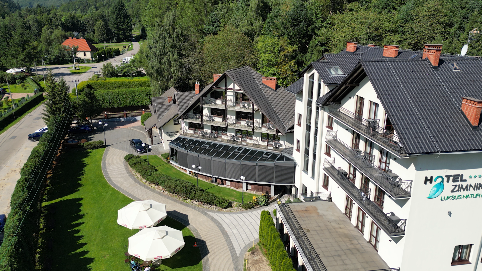 Kompleks hotelowy w otoczeniu leśnym.